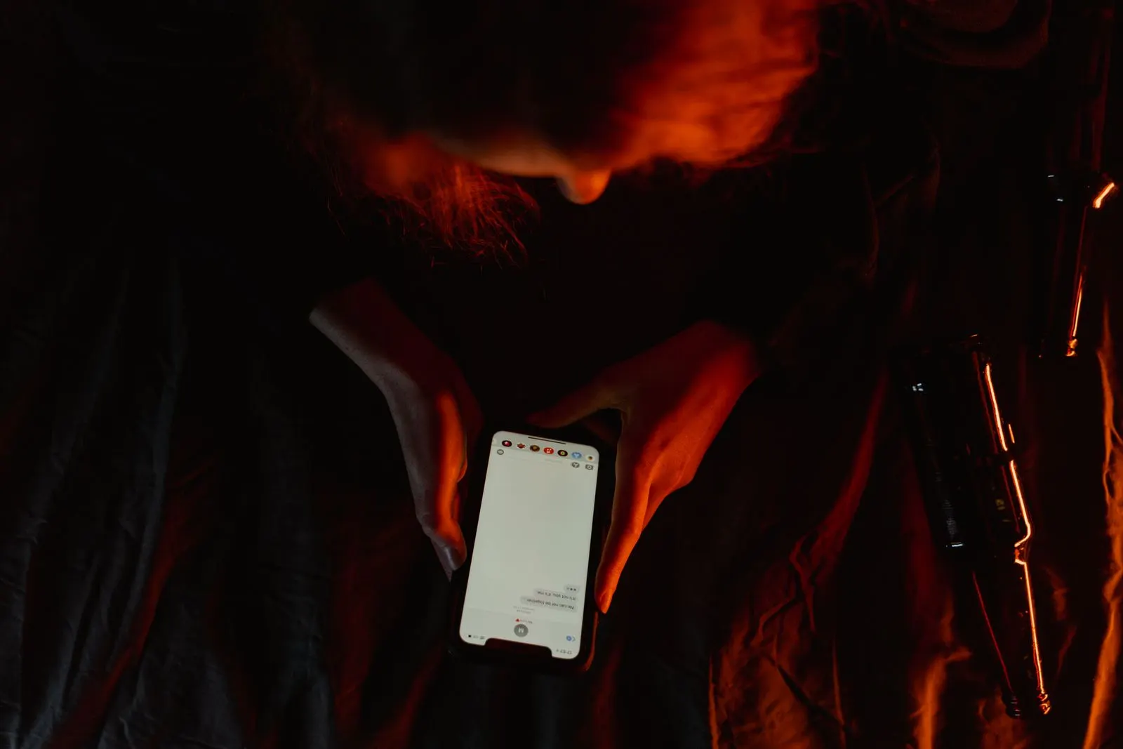Person scrolling on a smartphone in dim light
