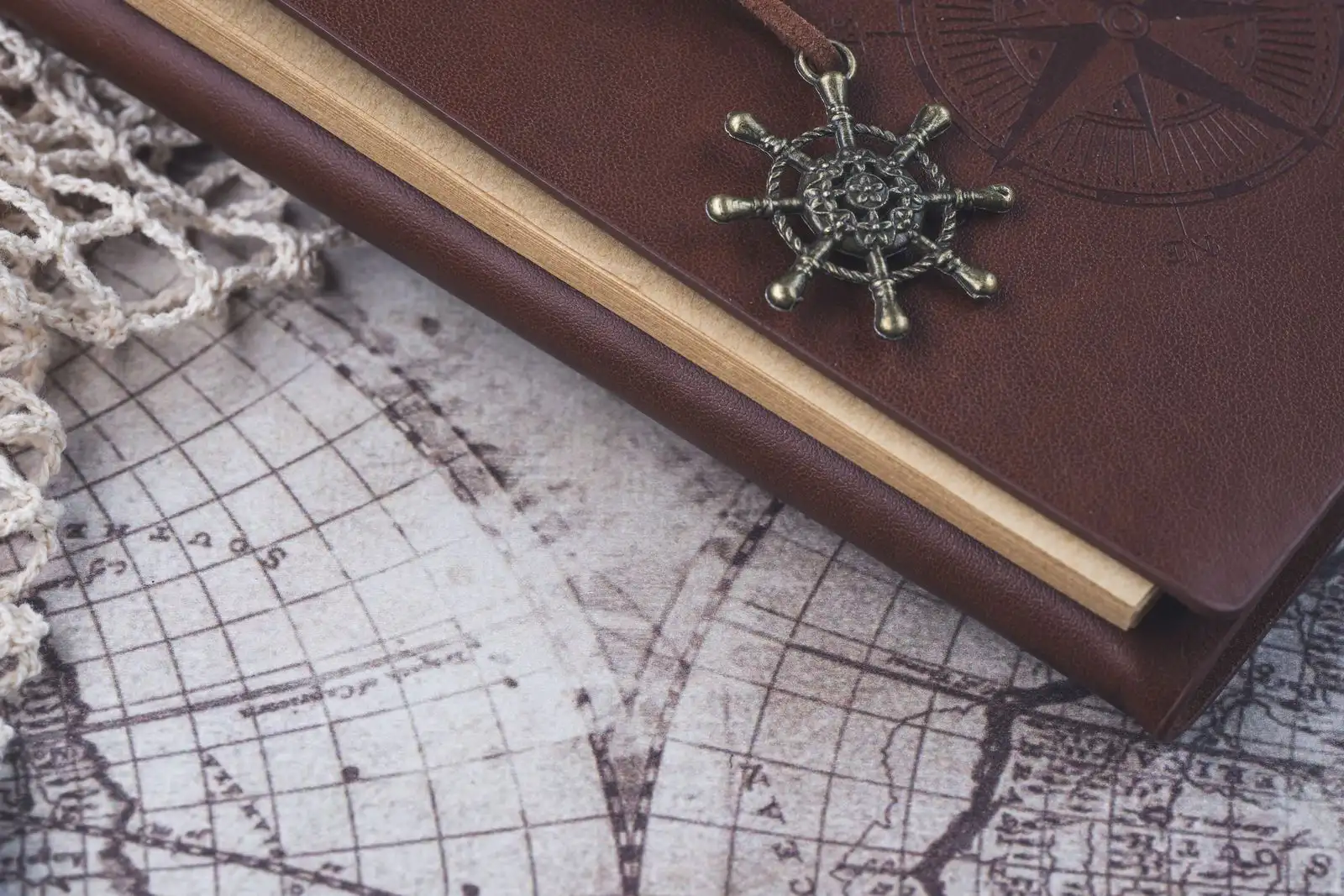 A leather-bound journal resting on an antique world map